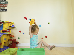 A toddler throwing toys