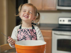 little girl stirring food in a bowl