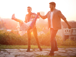 two men playing with little happy girl in a park