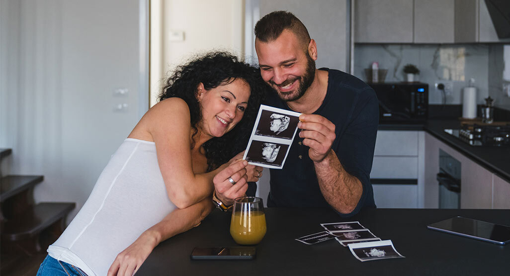 woman and partner looking at ultrasound photos