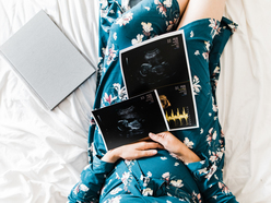 pregnant woman holding ultrasound images