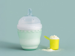 A person holding a baby formula can in a store